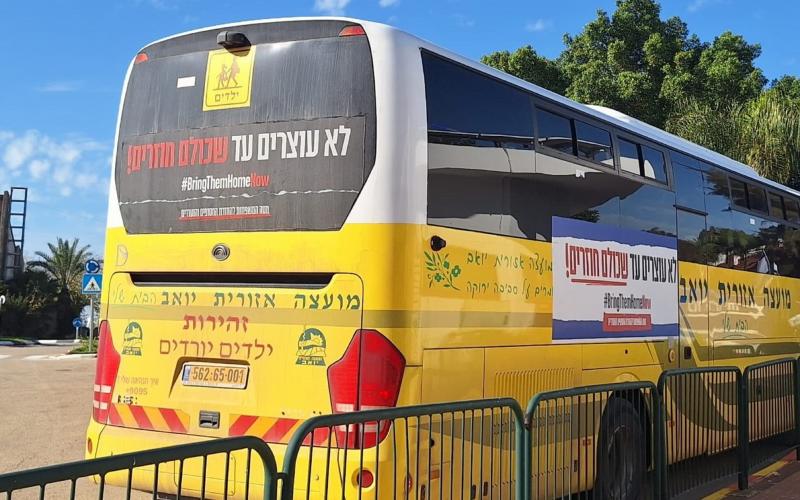 אוטובוס צהוב של המועצה האזורית יואב עם שלטים הקוראים להחזרת החטופים. שילוט האוטובוסים יצא לדרך