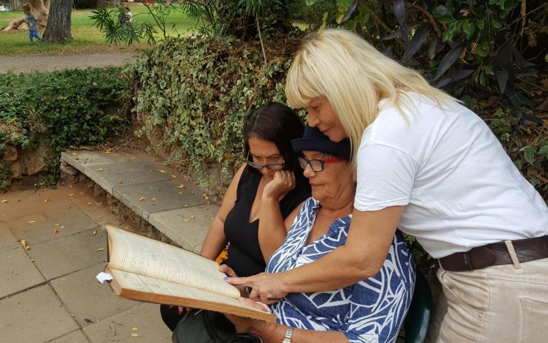 שושנה (עומדת), אחותה מזל ואחייניתם קוראות את ההספד שנכתב על יצחק ז"ל בעלון מעברות